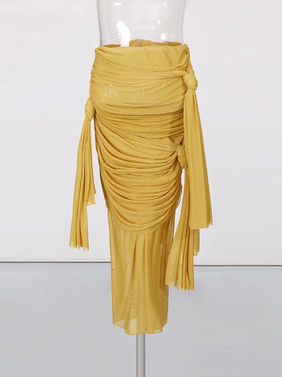 Mustard yellow draped skirt on a mannequin against a white background