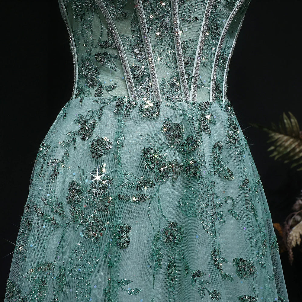 Green evening gown with floral and bead detailing on a black background