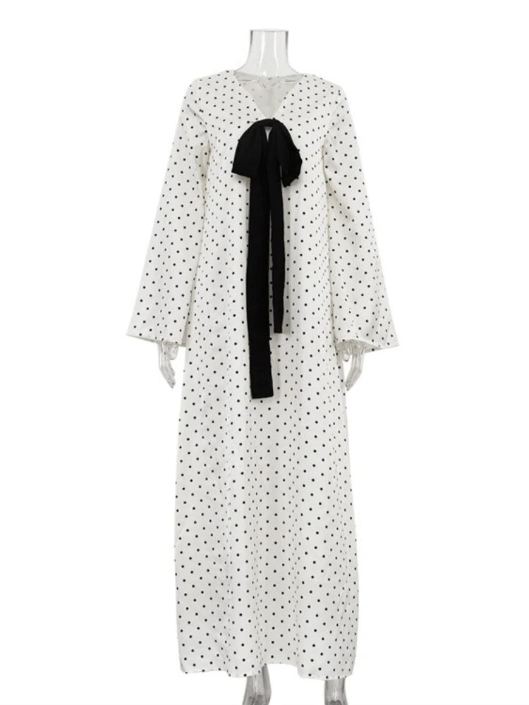 White dress with black polka dots and a black bow on a mannequin