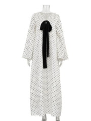 White dress with black polka dots and a black bow on a mannequin