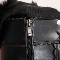Close-up of a black leather bag with a heart design and zipper detail.