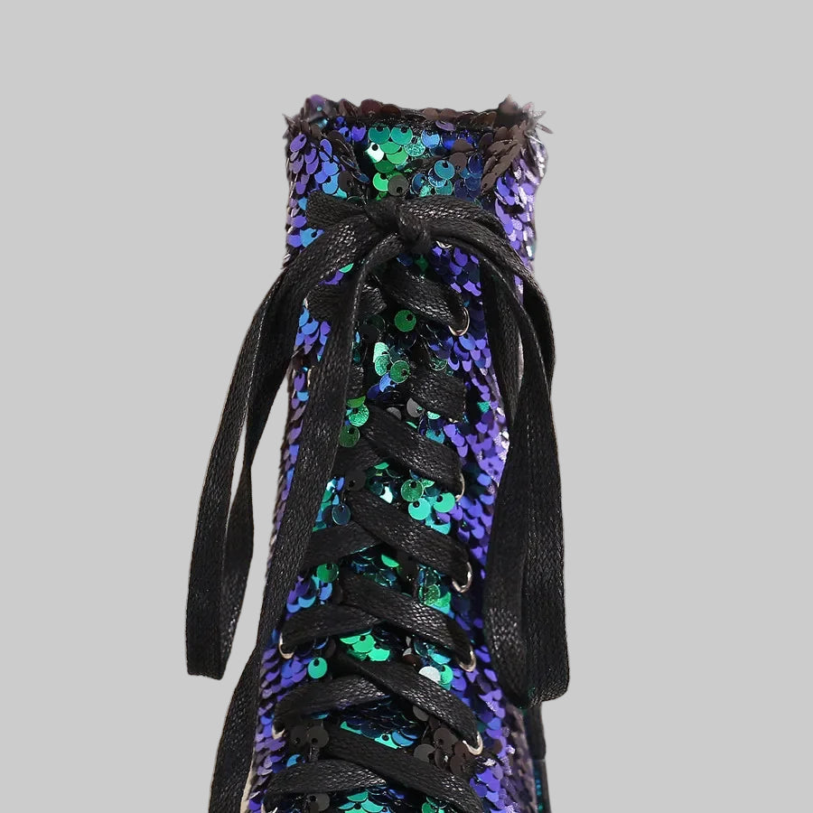 Black sneaker with blue and green sequins on a glittery background