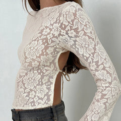 White lace top worn by a person on a plain background