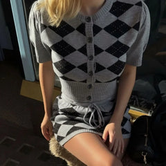 Person wearing a black and white checkered outfit sitting on a chair.