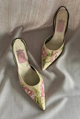 Pair of floral high-heeled shoes on a light fabric background