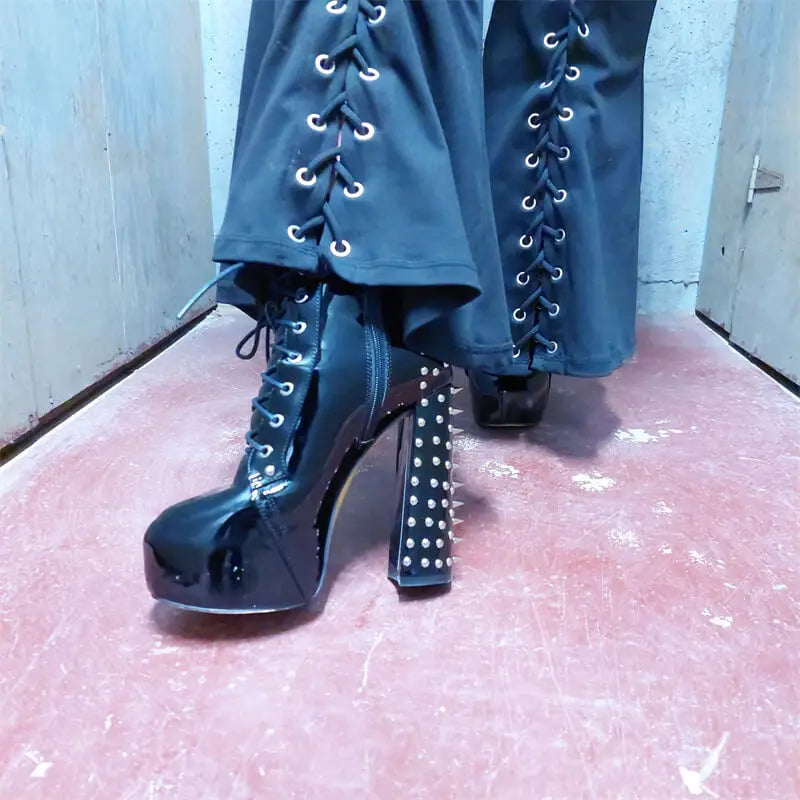 Model wearing spiked platform chunky heel boots