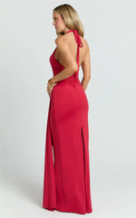 Woman wearing a red halter neck gown on a white background
