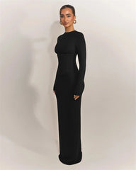 Woman wearing a black long-sleeve gown against a plain background