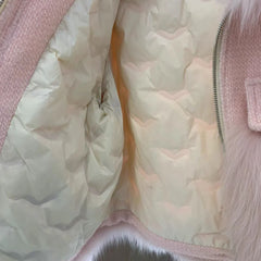 Close-up of a light pink puffer jacket with quilted design.