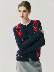 Woman wearing a navy blue sweater with red and white argyle pattern on a light gray background