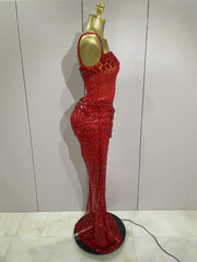 Red sequin dress on a mannequin against a white wall.