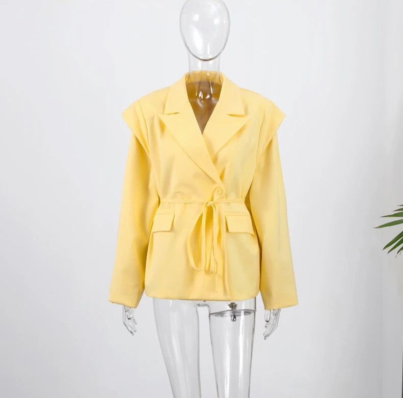 Yellow blazer on a mannequin against a white background