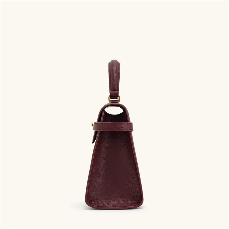 Brown leather handbag with a handle on a white background