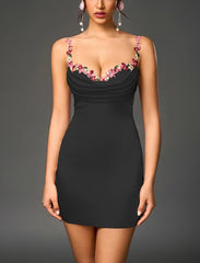 Black dress with floral embellishments on a gray background
