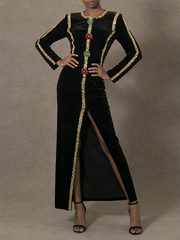 Black dress with gold and red embellishments on a gray background