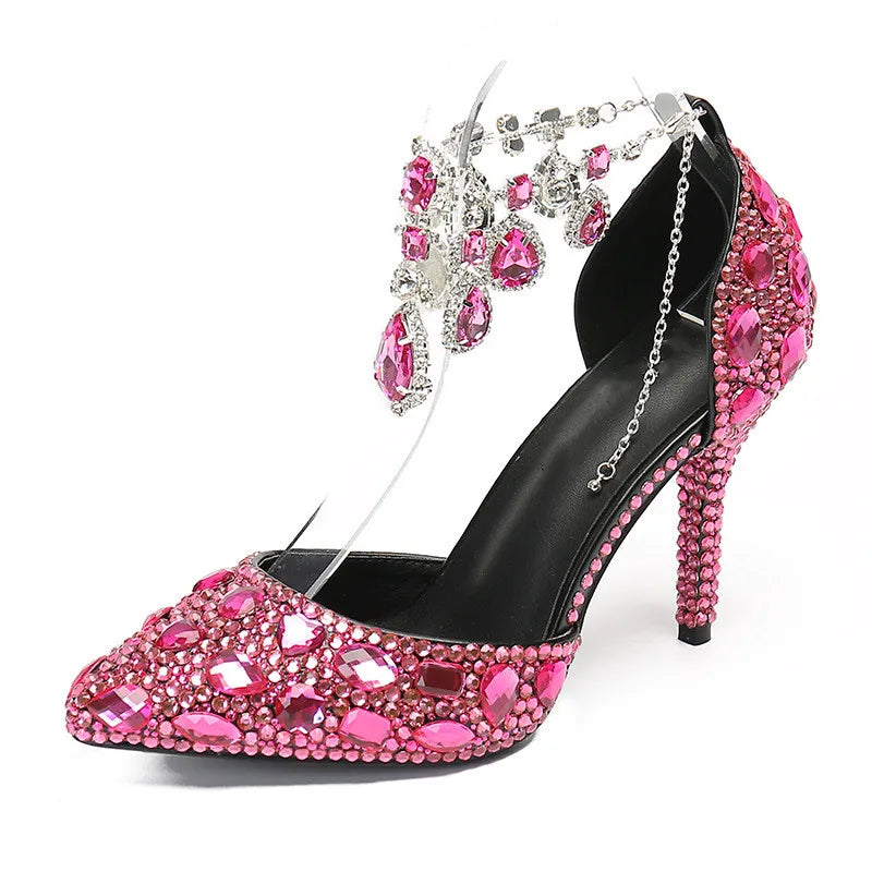 Pink high-heeled shoe with gemstones and a matching tiara on a white background