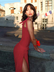 Woman in a red dress standing on steps with a building in the background