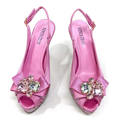 Pink high-heeled shoes with crystal embellishments on a white background