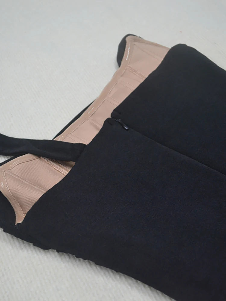 Black pants with beige lining on a textured surface