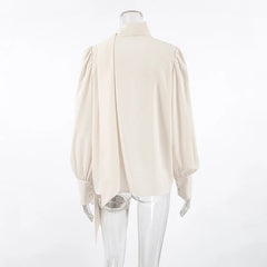 Beige blouse on a mannequin against a white background