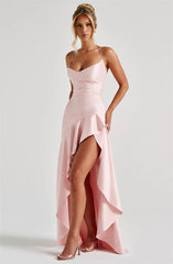 Woman wearing a pink evening gown with a high slit on a white background