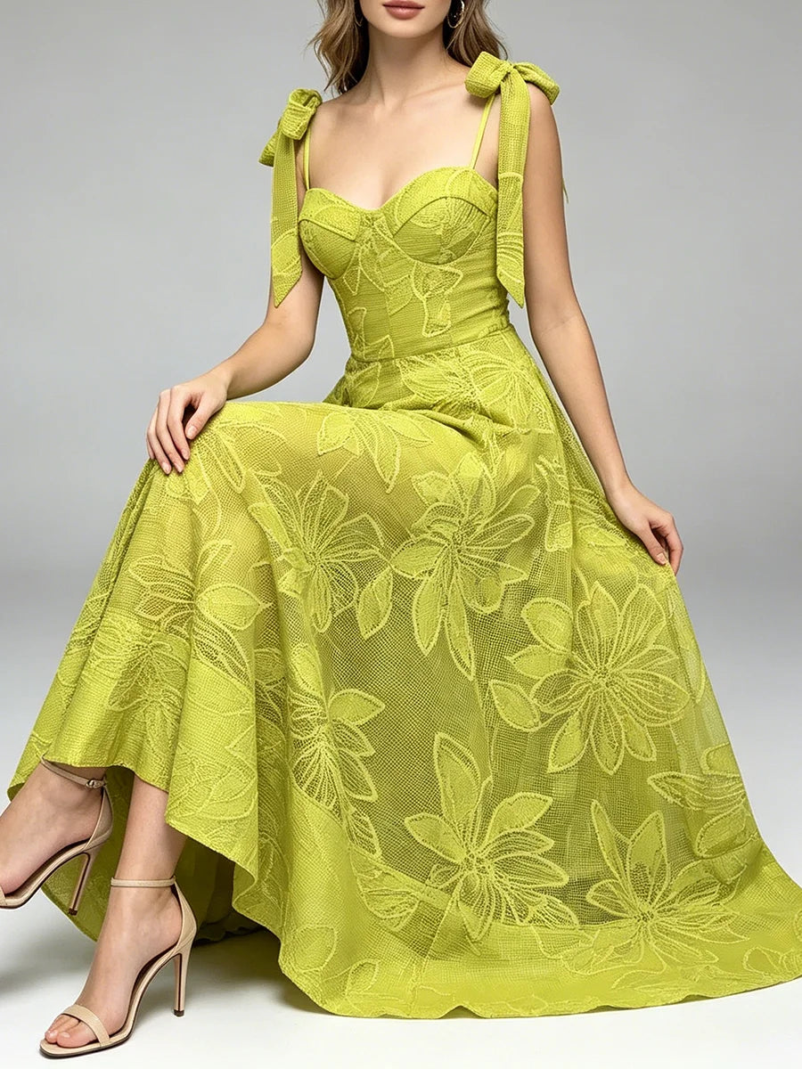 Woman sitting in a green floral lace midi dress with tie shoulder straps