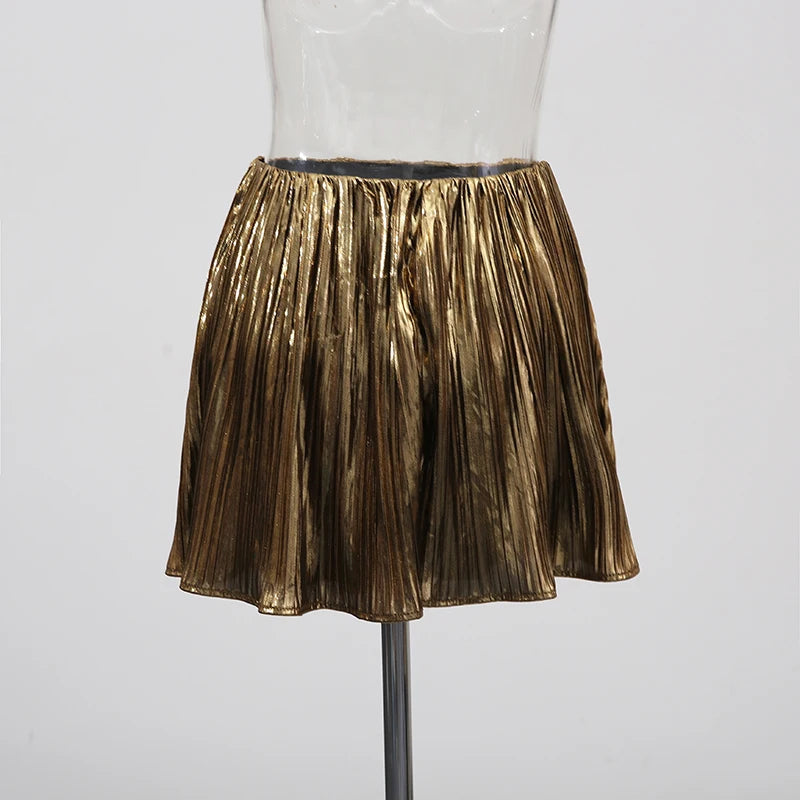 Gold pleated skirt on a mannequin against a white background