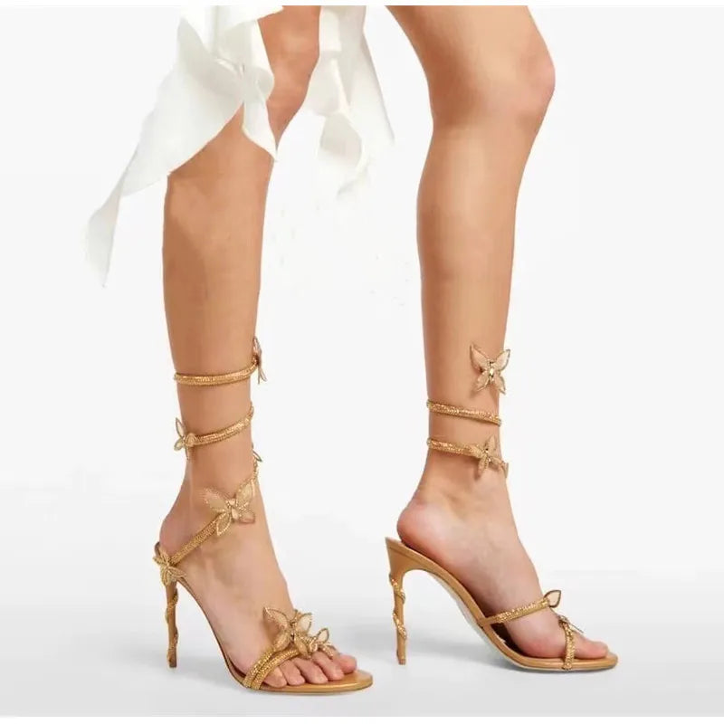 Gold high-heeled sandals with butterfly details