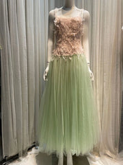 Mannequin wearing a dress with a pink top and green skirt against a neutral background