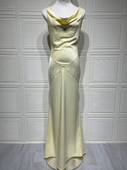 Light green evening gown on a mannequin against a white paneled wall.