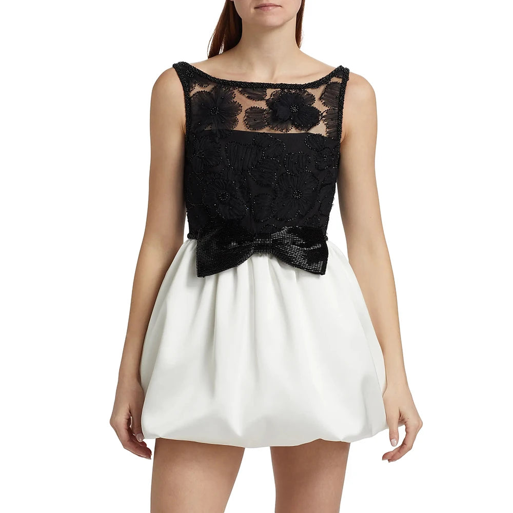 Black lace top and white skirt dress on a model against a white background