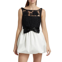 Black lace top and white skirt dress on a model against a white background