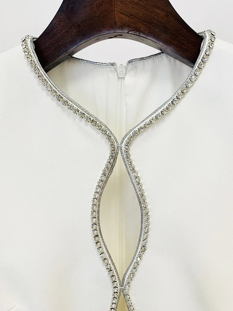 Close-up of rhinestone embellishment on the neckline of the white jumpsuit