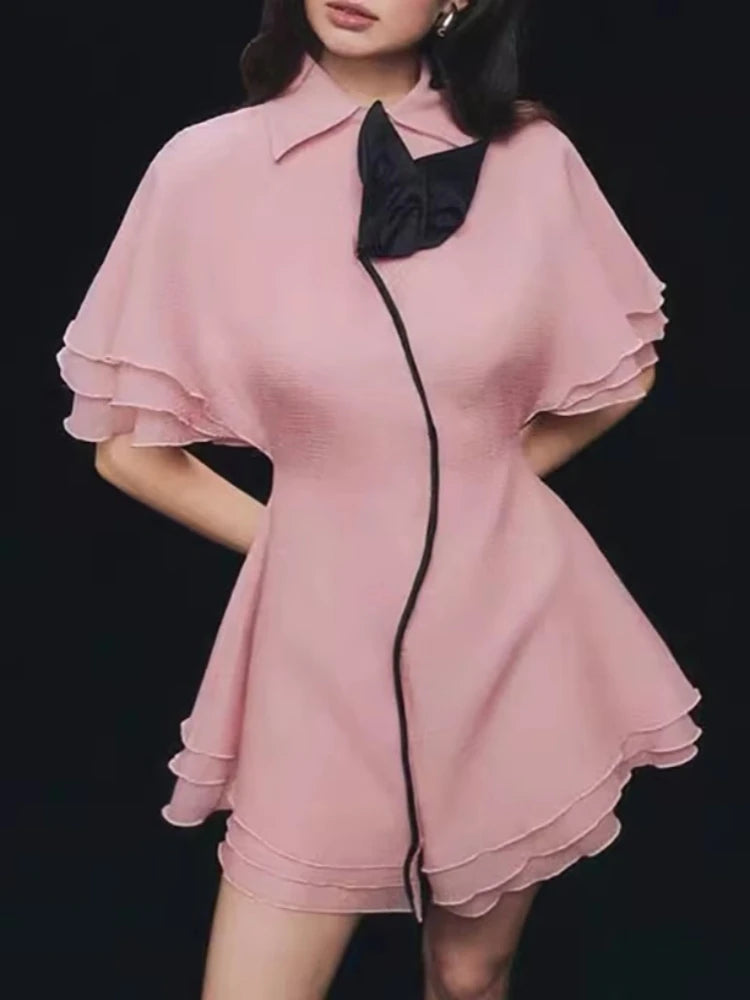 Pink dress with black trim on a black background