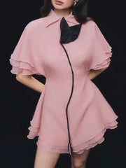 Pink dress with black trim on a black background