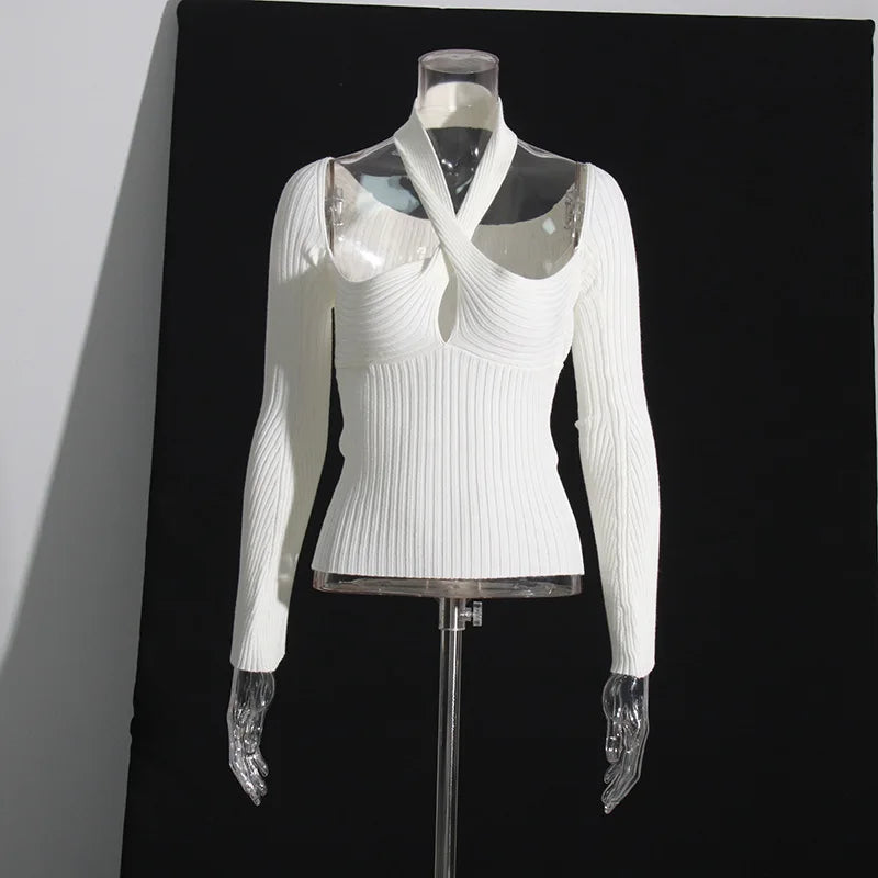 White ribbed sweater on a mannequin against a black background