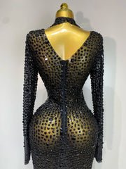 Black beaded dress on a mannequin against a white background