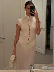 Woman taking a mirror selfie wearing a beige dress with button details.