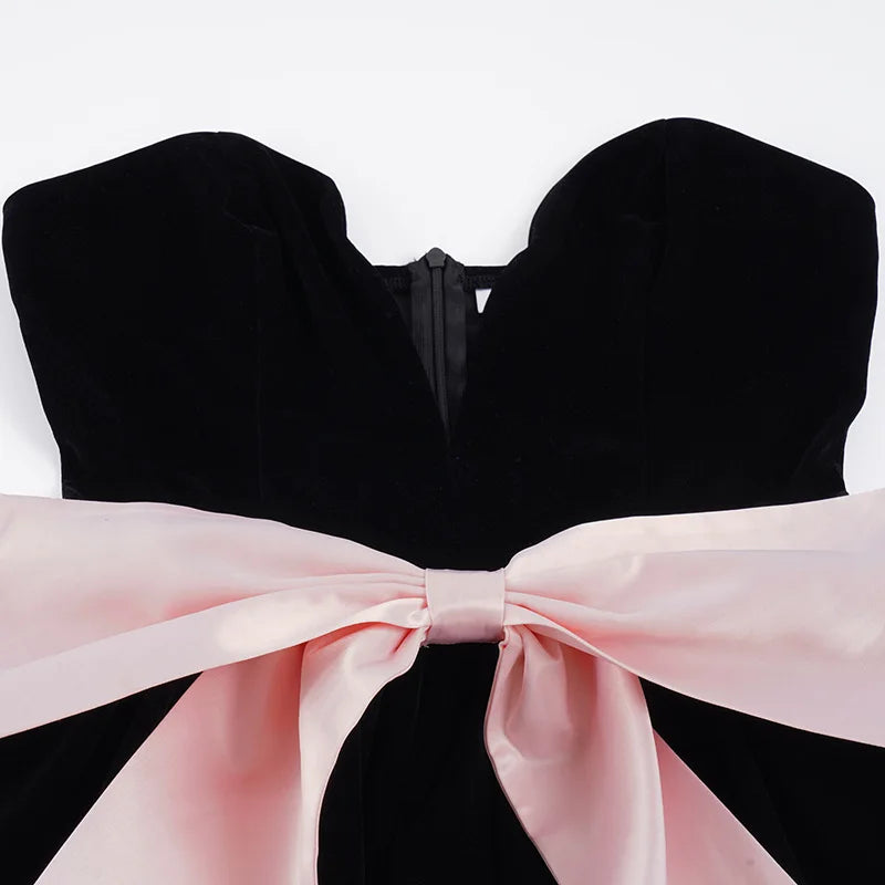 Black strapless top with a large pink bow on a white background