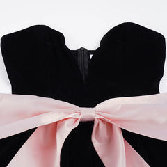Black strapless top with a large pink bow on a white background