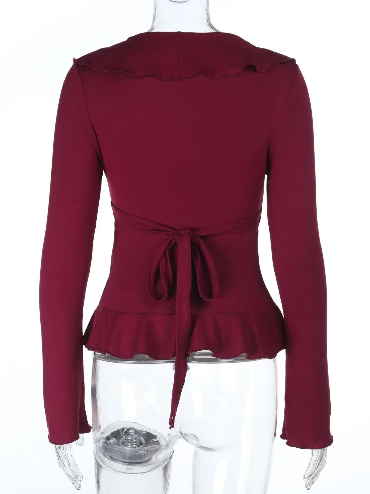 Maroon peplum top on a mannequin with a white background