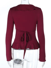 Maroon peplum top on a mannequin with a white background