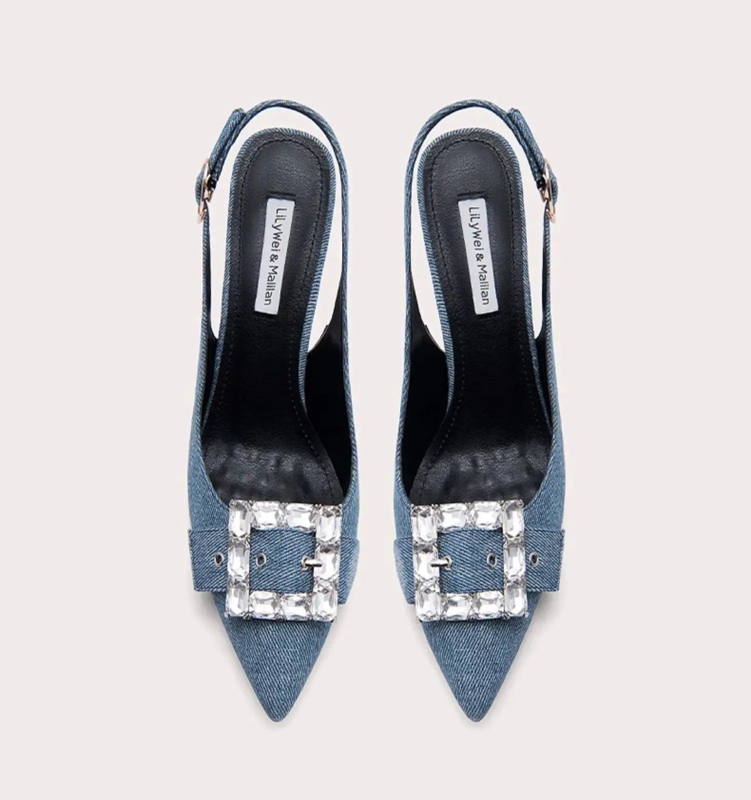 Blue high-heeled shoes with embellished buckles on a light gray background