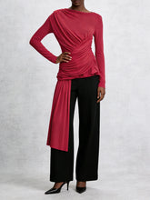 Person wearing a red long-sleeve top and black pants on a white background