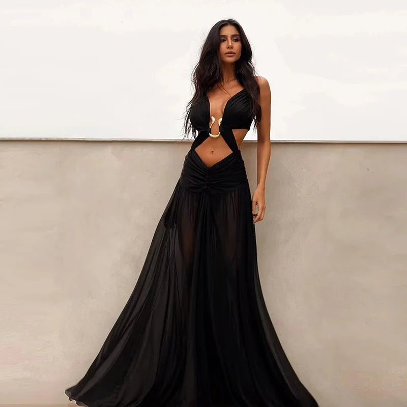 Woman wearing a black evening gown with cut-out design against a neutral background