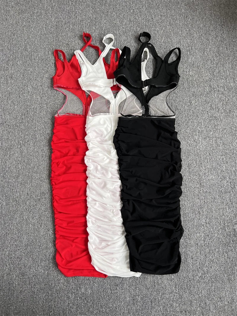 Three dresses in red, white, and black on a gray surface