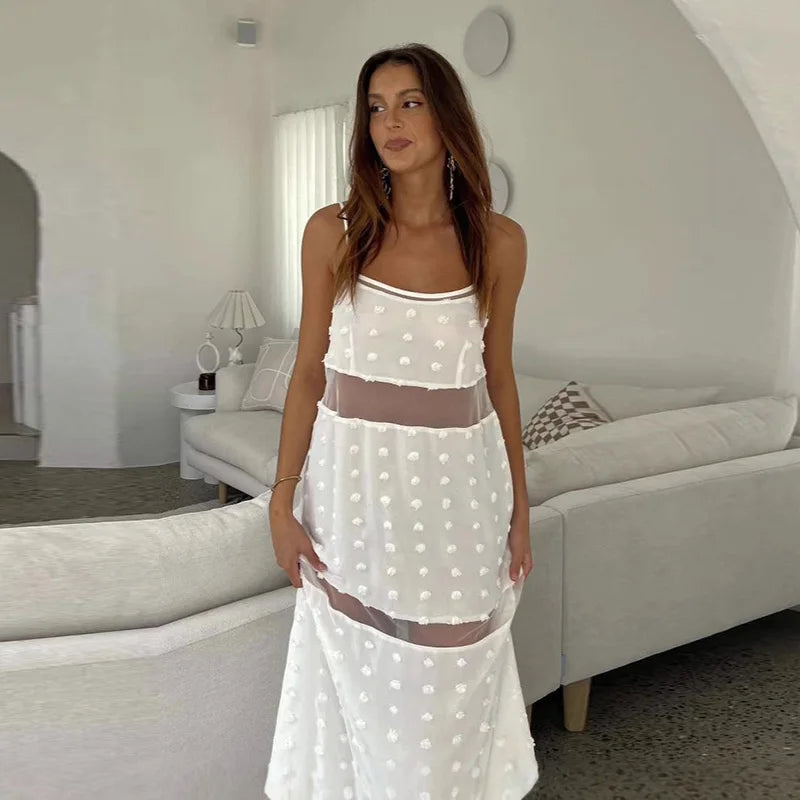 Woman wearing a white polka dot dress in a modern living room.