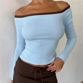 Light blue off-shoulder long-sleeve top with brown trim worn by a person against a plain background