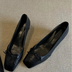Close-up of the bow detail on a square toe heeled Mary Jane shoe