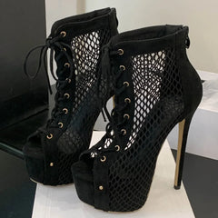 Black suede high-heeled boots with mesh design on a white surface.